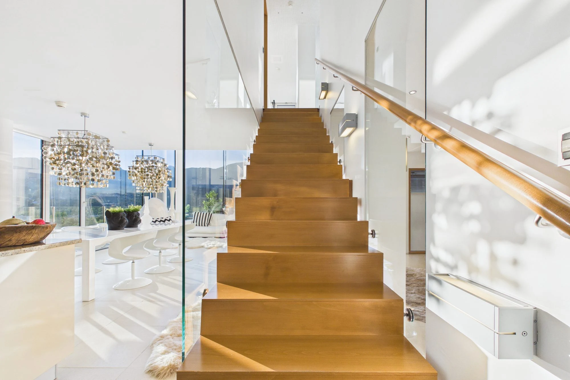 Holztreppe mit Glasgeländer zwischen den beiden Ebenen